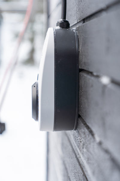 go-e latausasema rakennuksen ulkoseinässä talvella